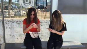 Otobüs beklerken kitap okutan