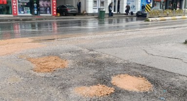 İhmalkârlık pes dedirtti, esnaf kovayla kum taşıyarak çukurları kapattı