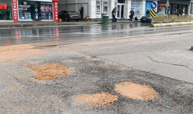 İhmalkârlık pes dedirtti, esnaf kovayla kum taşıyarak çukurları kapattı